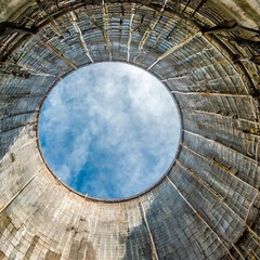 Fototapeta premium Inside a cooling tower of a nuclear power plant. View upwards, sky with haze