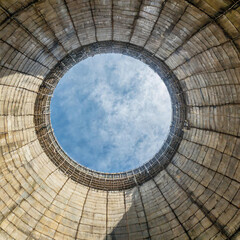 Naklejka premium Inside a cooling tower of a nuclear power plant. View upwards, sky with haze