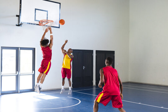 Young African American man scores in basketball game, with copy space