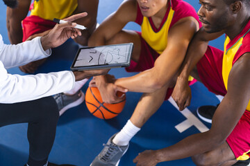 African American men review basketball strategy on a digital tablet