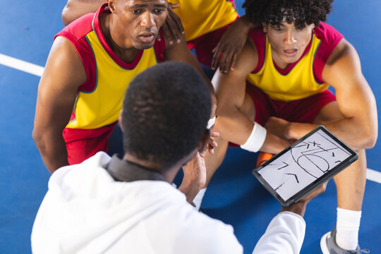 Diverse basketball team discusses strategy during a timeout