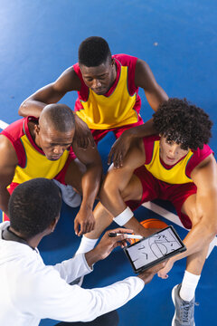 Diverse basketball team discusses strategy on court