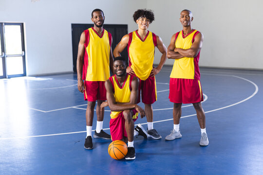 Diverse basketball players pose in a gym
