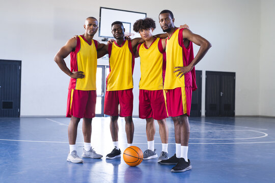 Diverse basketball team poses confidently on the court