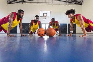 Diverse basketball players are in a gym, with copy space