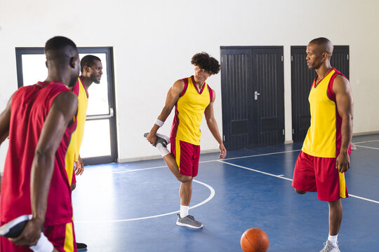 African American and biracial men play basketball indoors