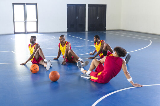 Diverse basketball players take a break on the court - Powered by Adobe