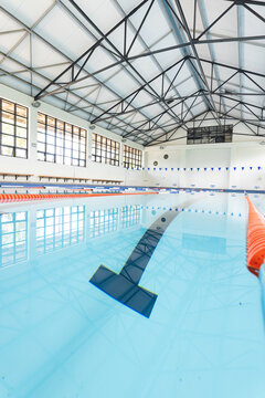 An indoor swimming pool awaits swimmers, with copy space