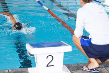 Swimmer dives into the pool during a competition