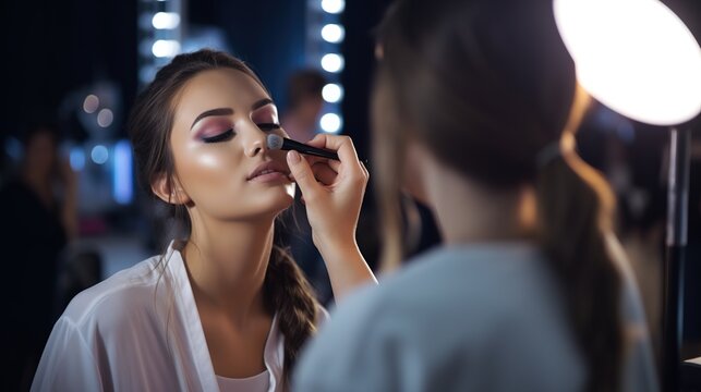 Makeup artist applies applies powder and blush . Beautiful woman face. Hand of make-up master puts blush on cheeks beauty model girl . Make up in process