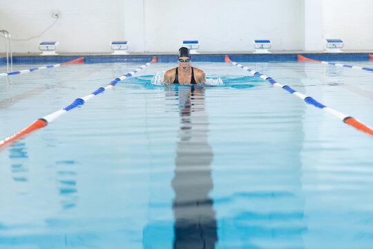 Caucasian female athlete swimmer swimming laps in a pool