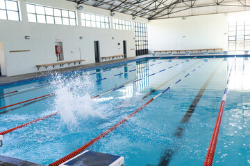 An indoor swimming pool awaits swimmers, with copy space