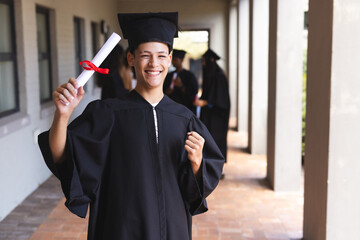 Biracial teenage boy celebrates graduation at high school
