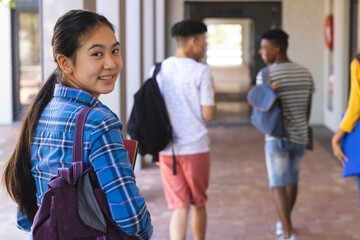 Teenage Asian girl and diverse friends at high school, with copy space