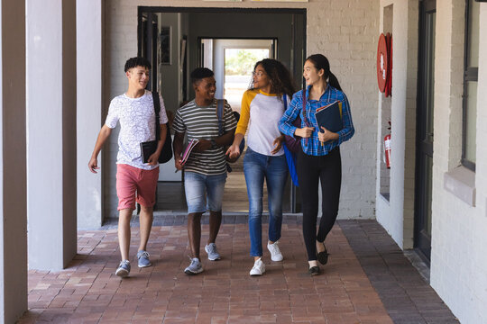 Diverse group of teenagers walking in a high school corridor