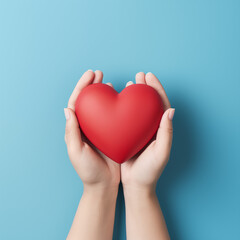 Hands gently holding a red heart against a light blue background. Symbolizes love, care, health, charity, and Valentine's Day. Simple and impactful image.