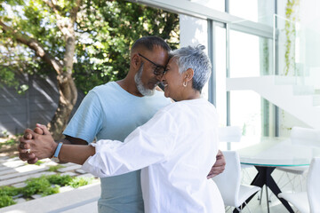 Senior biracial couple shares a tender moment at home