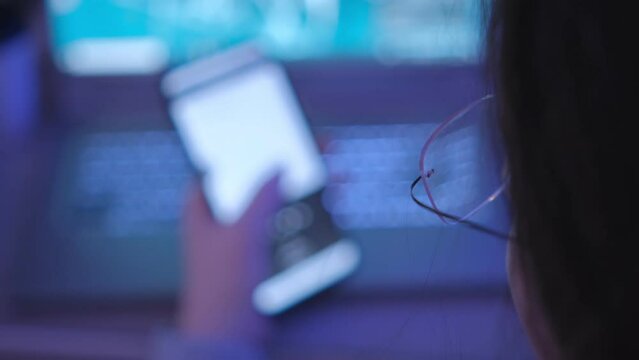 female student prepares homework using mobile phone laptop indoors slow motion. Casual woman searching information for project in smartphone 4K