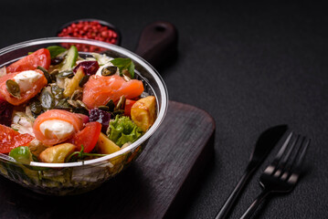 Delicious juicy salad with salmon, tomatoes, cucumber, herbs, pumpkin seeds