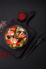 Delicious juicy salad with salmon, tomatoes, cucumber, herbs, pumpkin seeds
