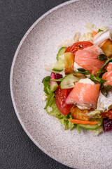 Delicious juicy salad with salmon, tomatoes, cucumber, herbs, pumpkin seeds