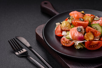Delicious juicy salad with salmon, tomatoes, cucumber, herbs, pumpkin seeds
