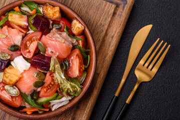 Delicious juicy salad with salmon, tomatoes, cucumber, herbs, pumpkin seeds