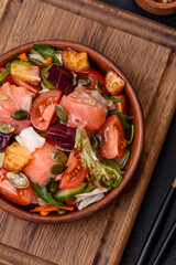 Delicious juicy salad with salmon, tomatoes, cucumber, herbs, pumpkin seeds