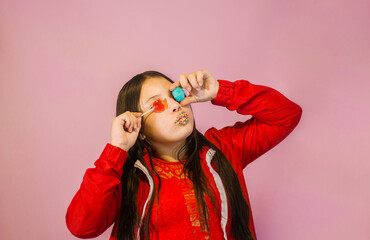 retrato en estudio de joven adolescente con caramelos en su rostro 