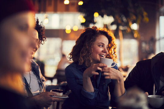 Happy woman enjoying hot chocolate in a cafe