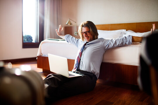 Mature businessman using a laptop in a hotel room