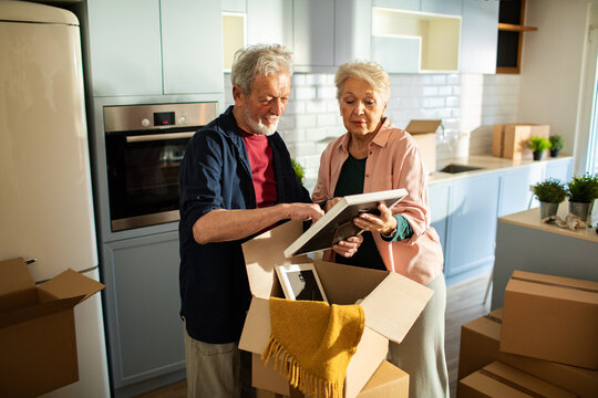 Senior couple unpacking items in new home