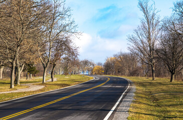 Fototapeta premium Empty road through the park in autumn