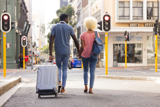 Fototapeta A diverse biracial couple walk in the city on vacation