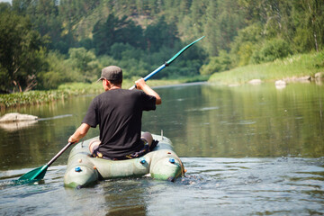A man paddles a kayak down a river, enjoying the scenic watercourse