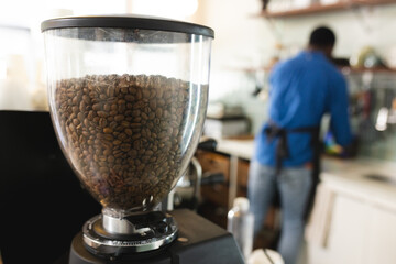 Coffee beans in a grinder at the forefront, with copy space