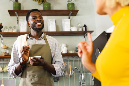 An African American barista takes an order at a cozy cafe