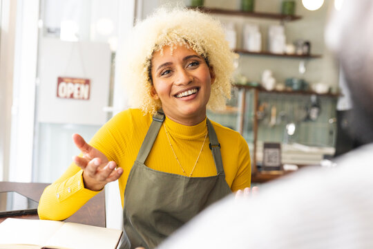A young biracial woman engages in conversation at a cafe