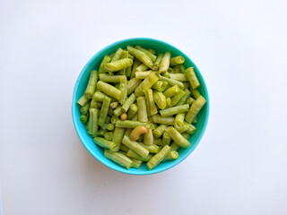 raw long beans in bowl on white background