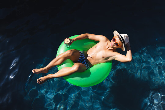 Young Asian man relaxes on a pool float