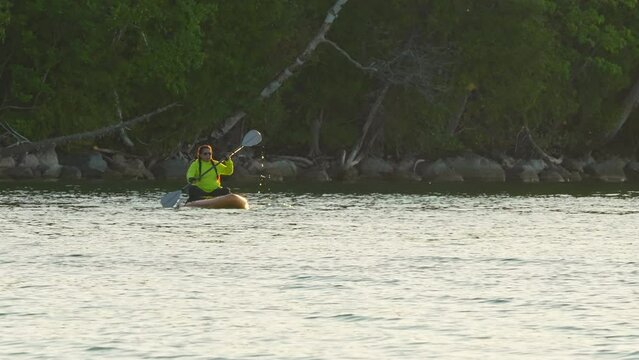 Woman cruising on stand-up paddleboarding SUP. Water sport with paddle at the water. Recreation and fitness. Exploring lake wilderness in Canada while getting a full-body workout. Adventure and sport.