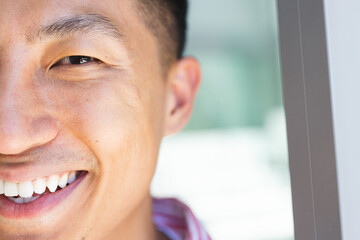 Close-up of a smiling young Asian man, with copy space