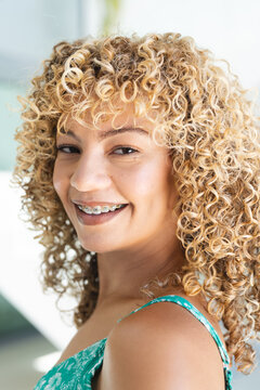 Fototapeta Young biracial woman smiles brightly, showcasing braces