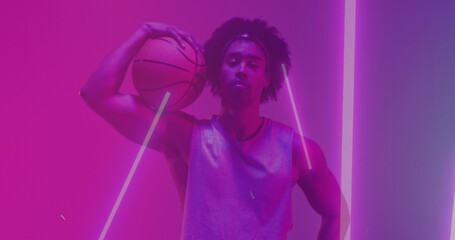 Image of confetti and neon pattern and biracial basketball player