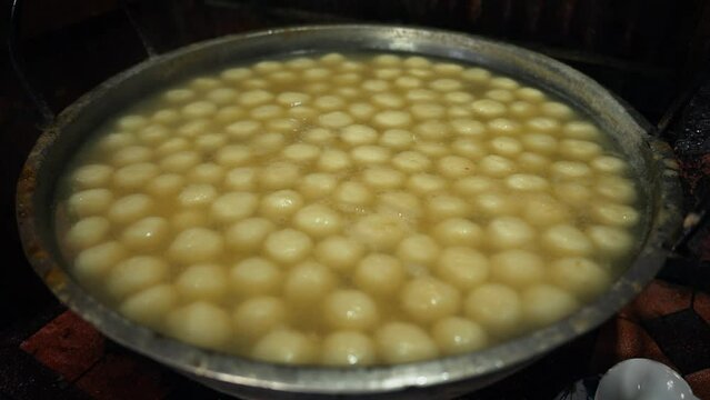 Art of making Rasgulla, a delightful Indian dessert made from milk solids, deep-fried to golden perfection and soaked in fragrant sugar syrup. Vibrant, aromatic, tempting. A feast for the senses