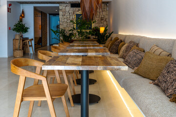 Entrance of a small luxury hotel with empty wooden tables out of season. Vacation concept