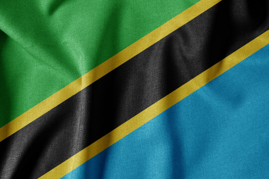 National Flag on Textured Fabric Background. Silk textured flag, realistic wave and flag look. TZ  Flag of Tanzania