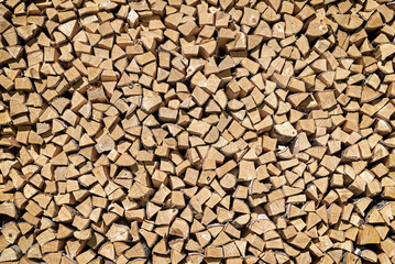 Birch firewood stacked in a woodpile, background.
