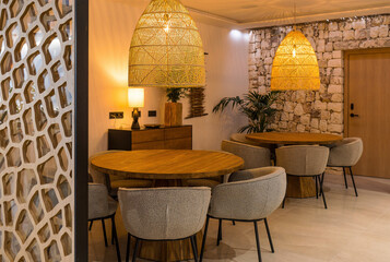 Hallway of a rustic hotel with round tables and warm light. Tourism concept