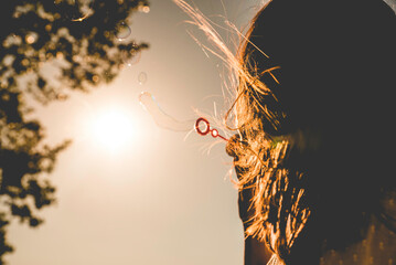 Chica haciendo pompas de jabón